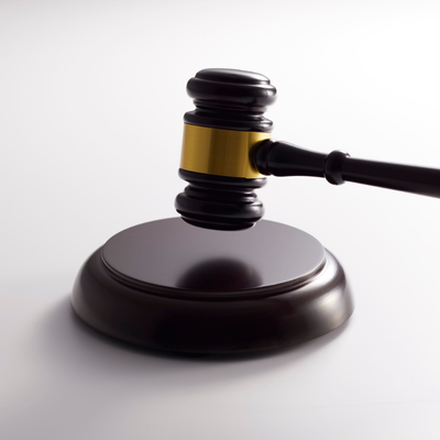 Close-up of a wooden judge’s gavel resting on a sound block, symbolizing law, justice, and legal proceedings.