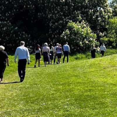 People in office clothing walking in groups in an open field