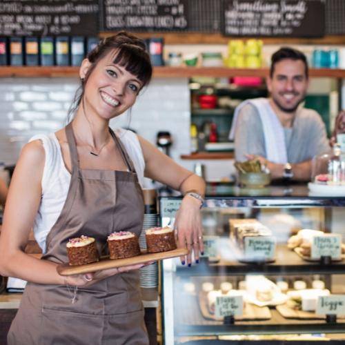 Woman and man in cafe holding baked goods